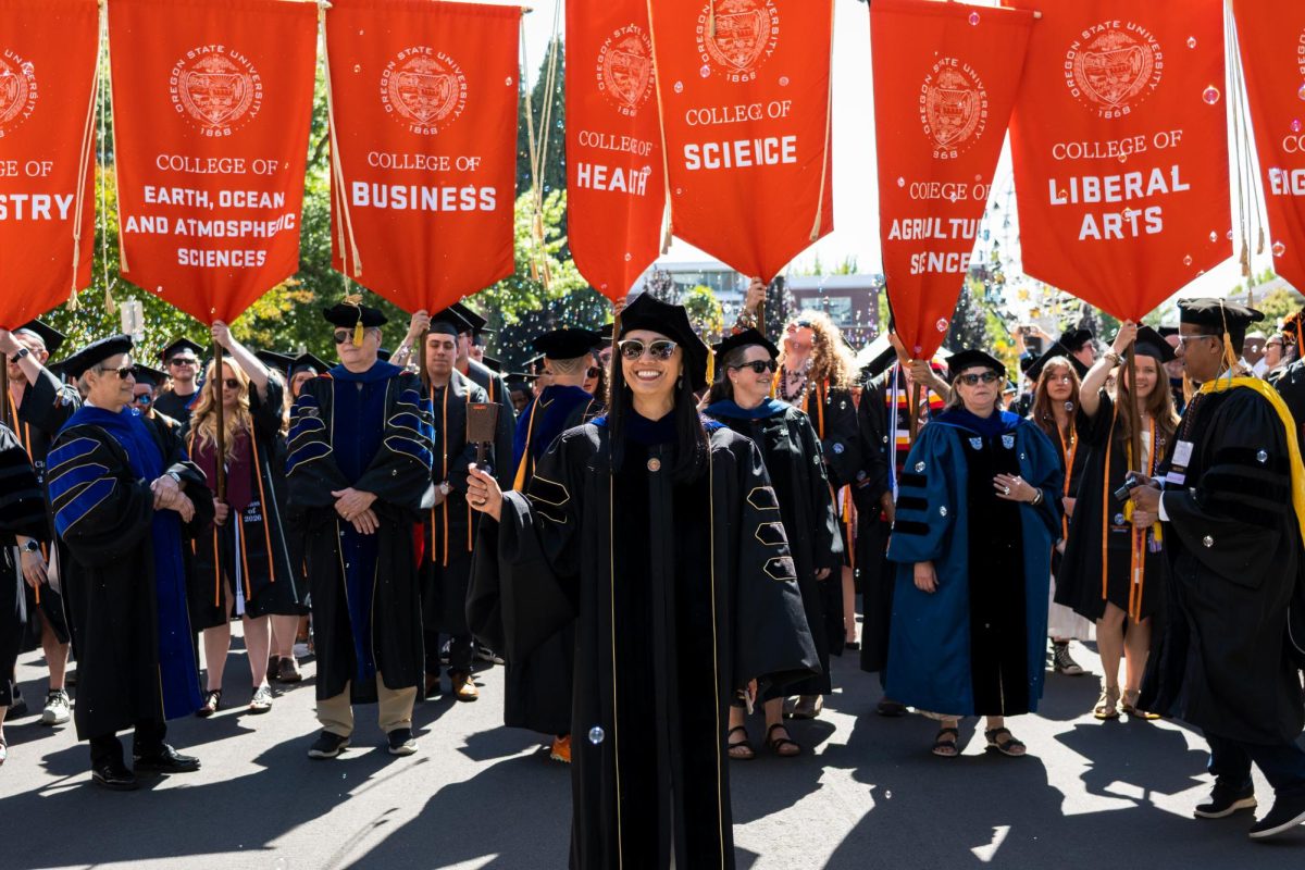 A woman leads a march with people holding banners above their heads behind her.