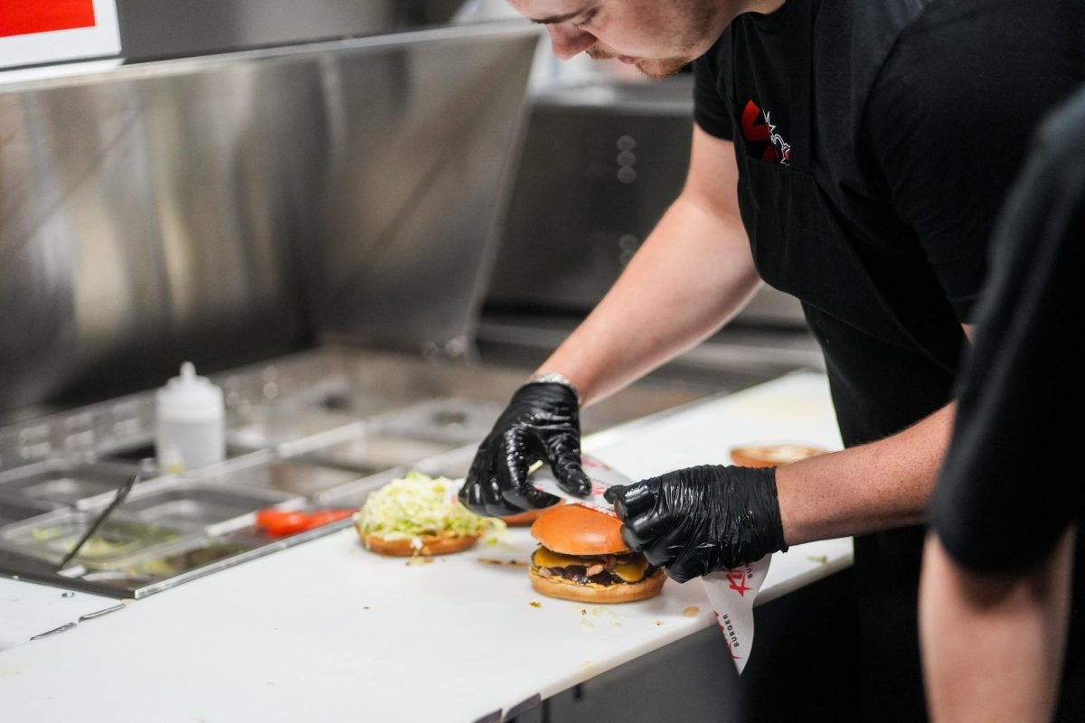 A Killer Burger employee begins to wrap a finished burger on June 16, 2026. Killer
Burger provides several gluten free and vegetarian options, catering to an array of
dietary needs.