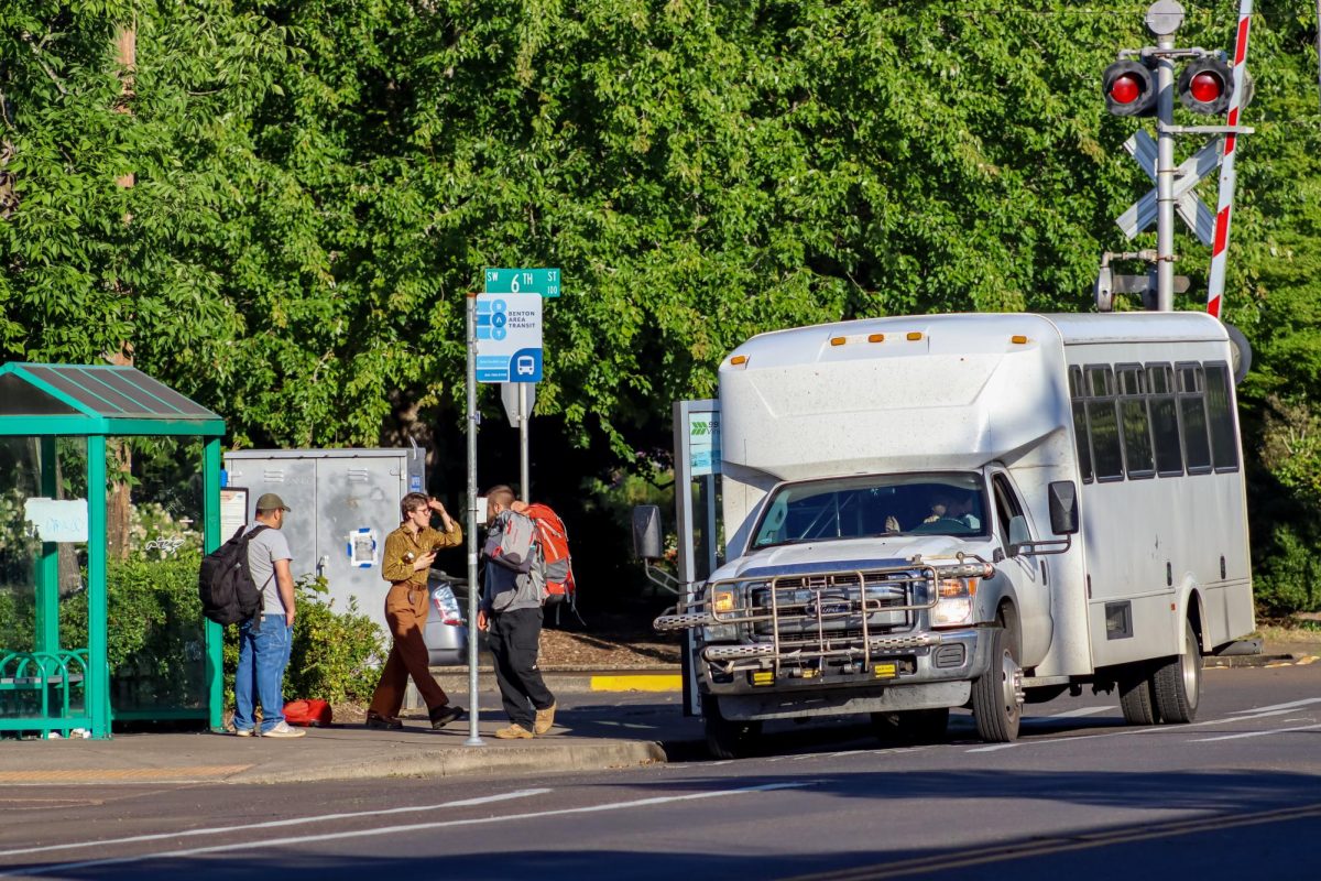 People waiting at a bus stop to get on a bus that just arrived.