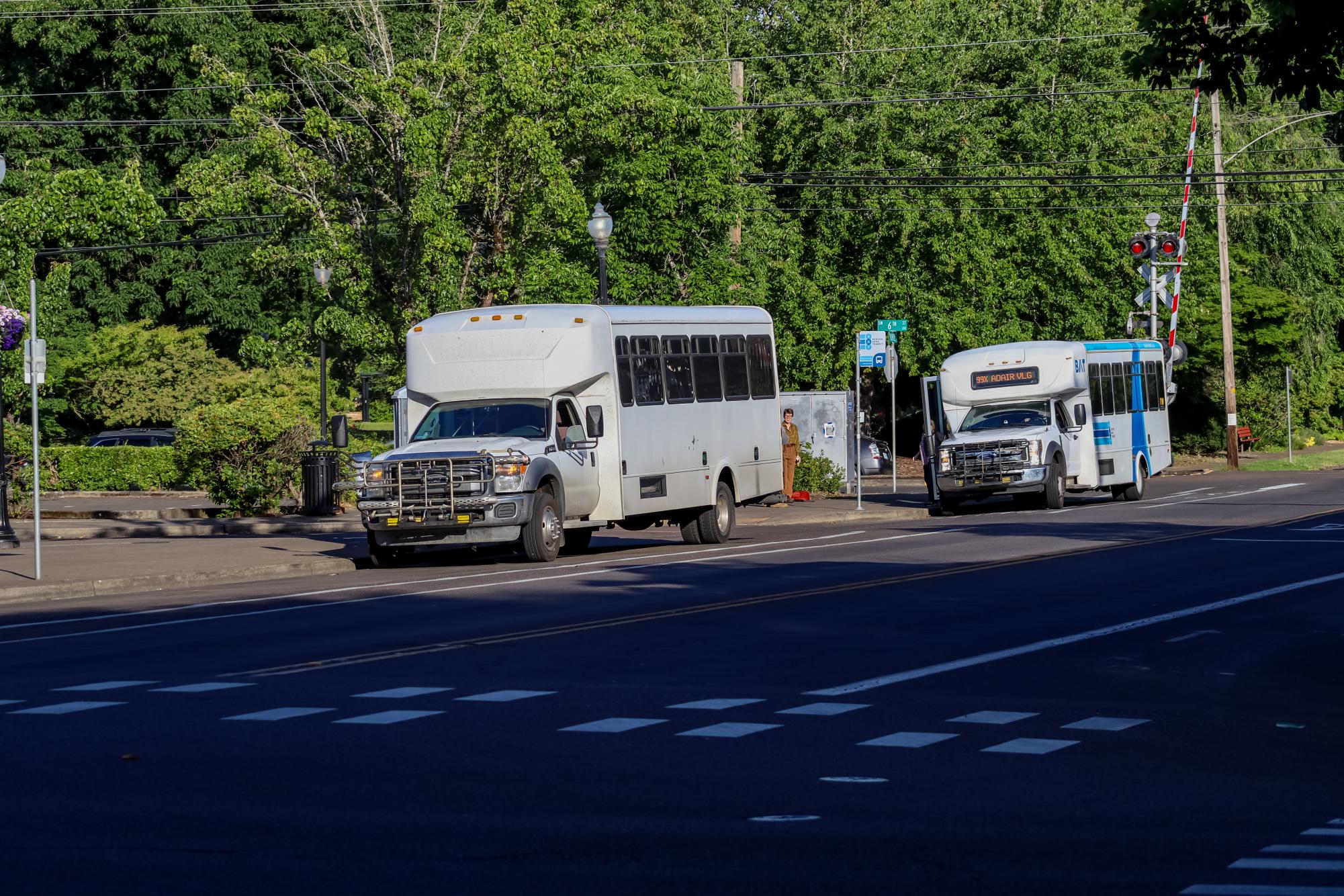 Busses at the transit center wait at a bus stop for passengers.