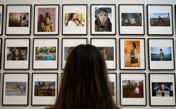 Back of woman's head in front of wall of photos.