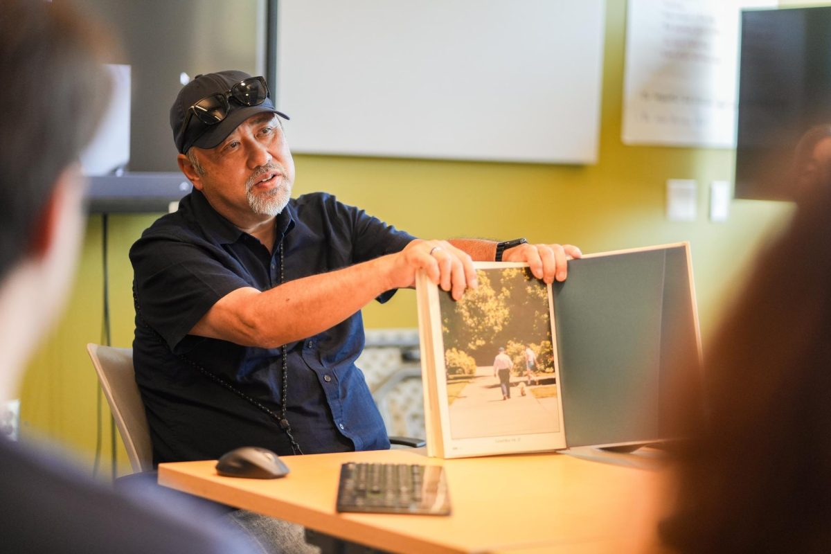 A man holds up a book to show a picture inside.