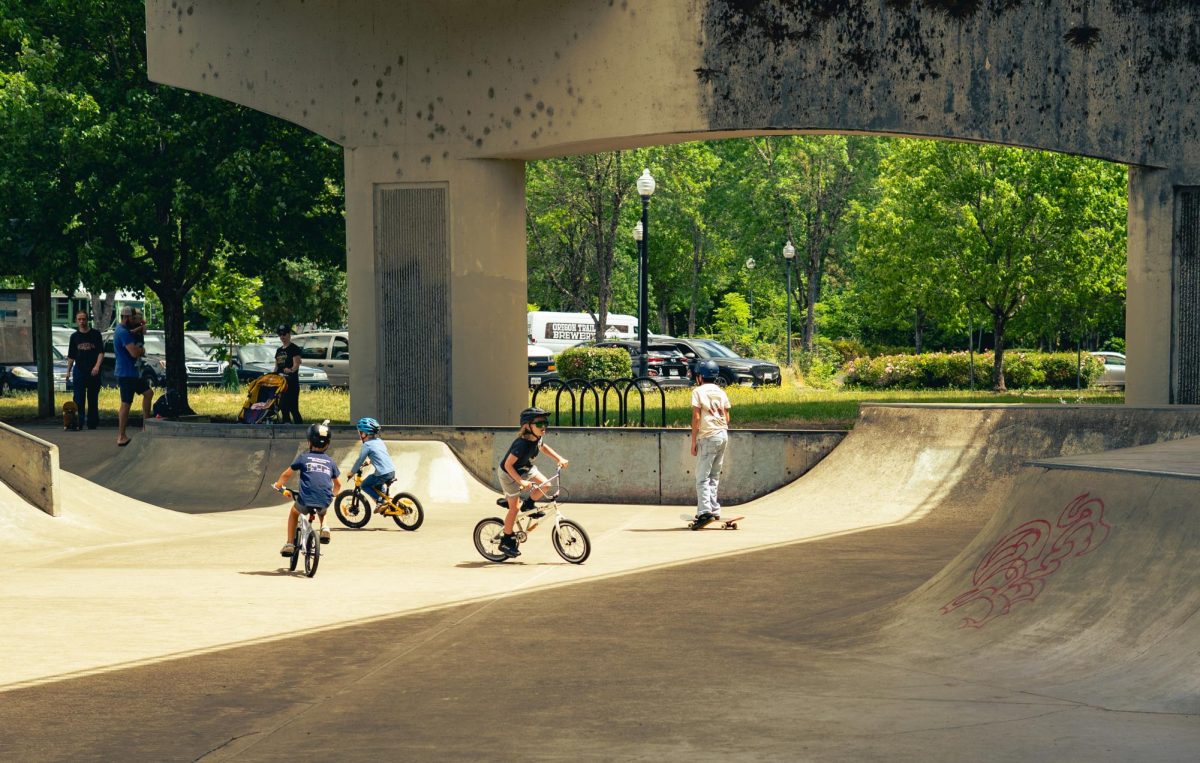 A group of kids bike in a skate park
